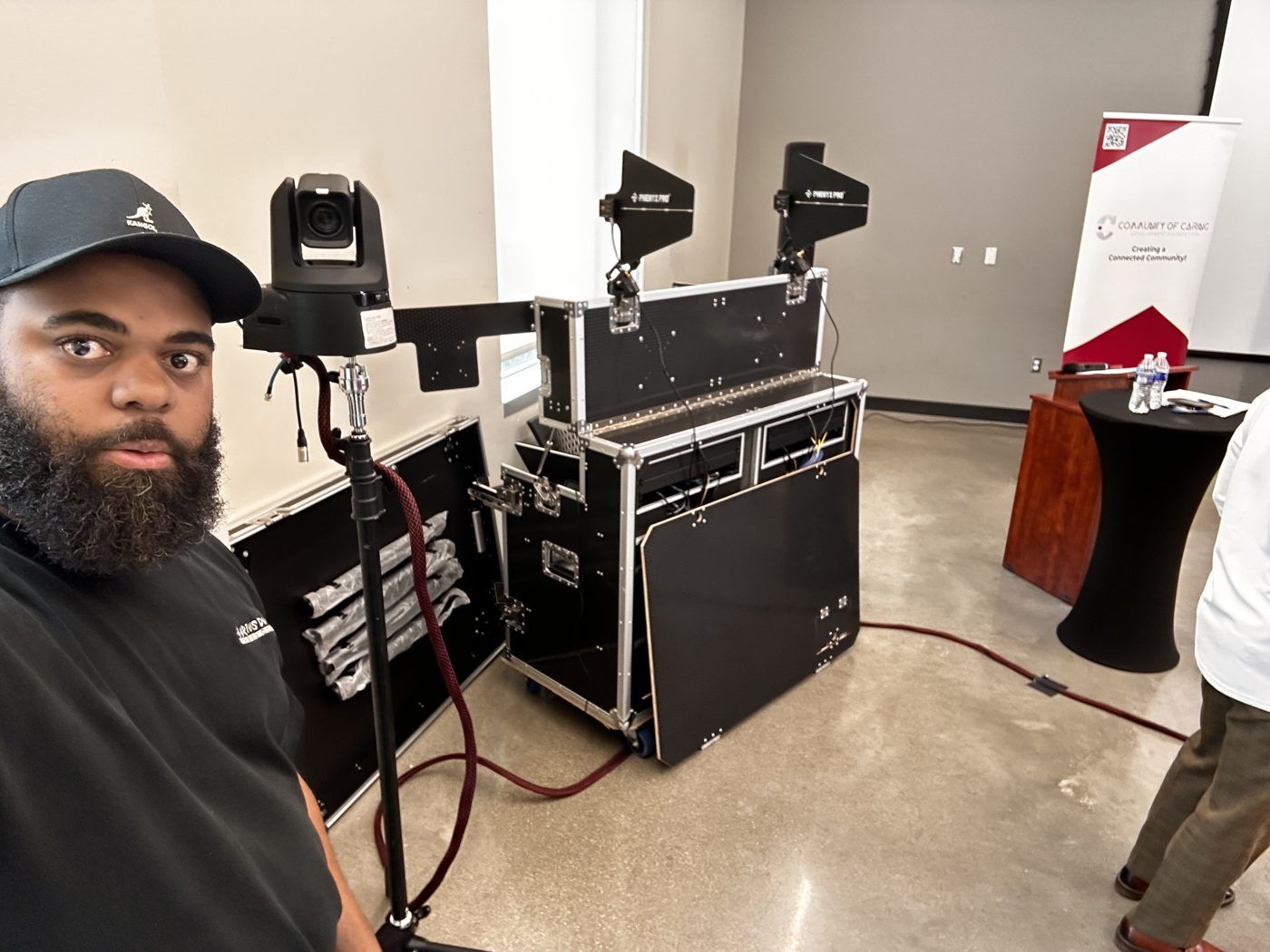 PTZ camera on a stand beside its road case