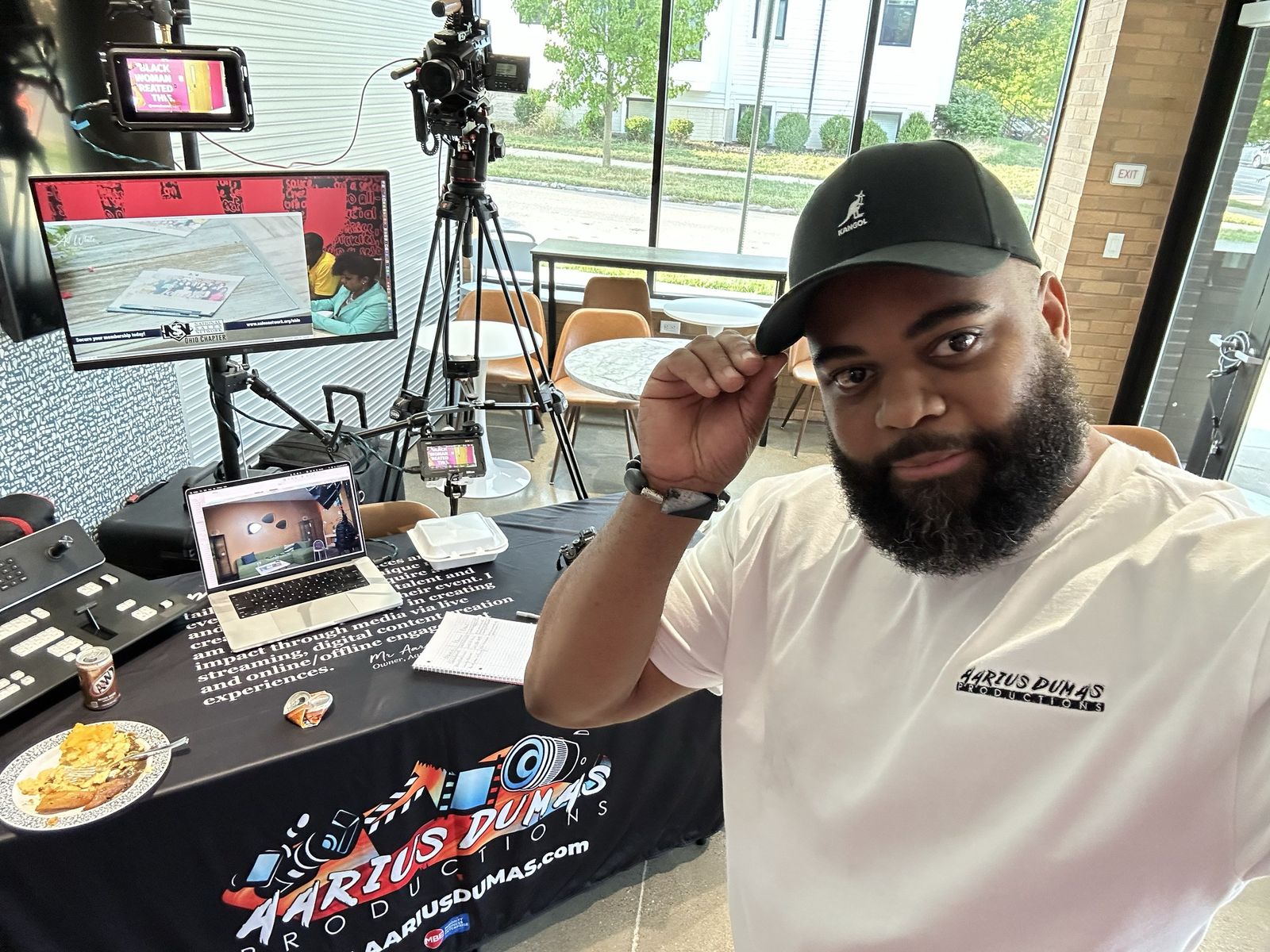 Aarius Dumas at the Aarius Dumas Productions vendor table at Zora’s House, with PTZ camera, switcher and monitors